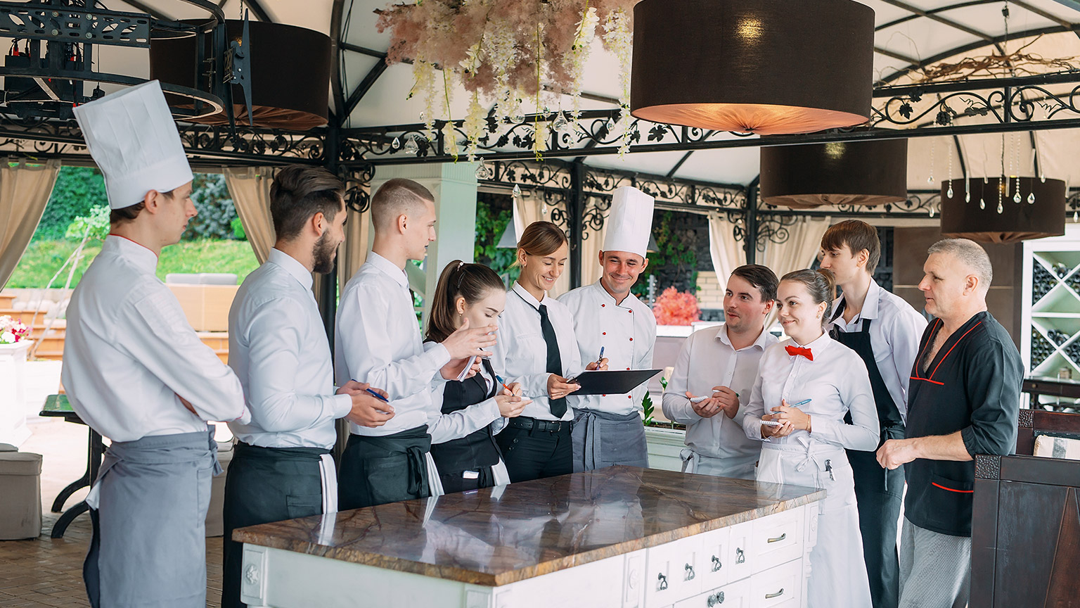 Restaurant manager and his staff in terrace. interacting to head chef in restaurant