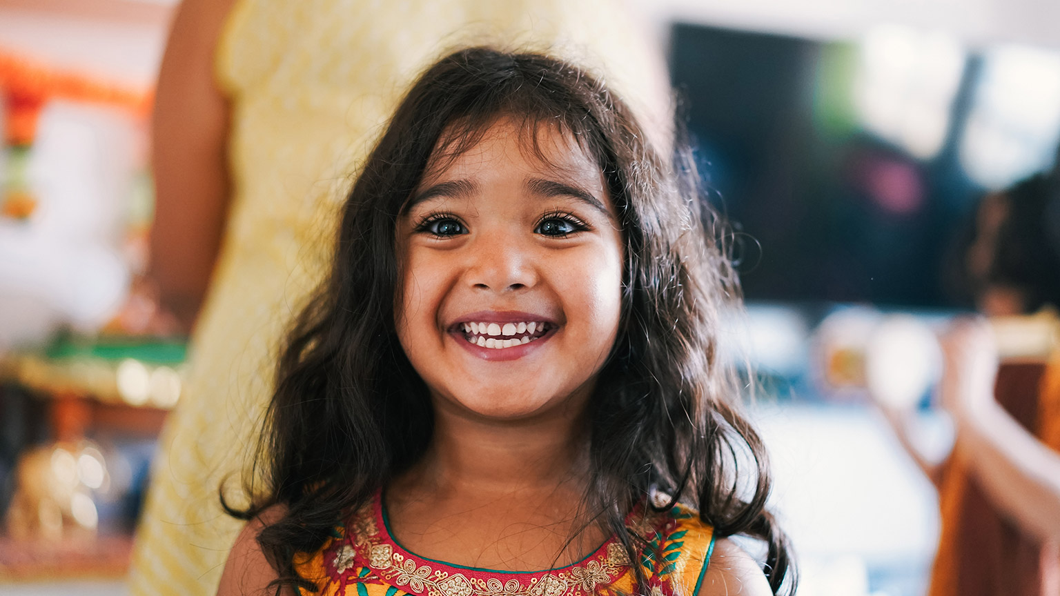 A young girl smiling in a childcare facility