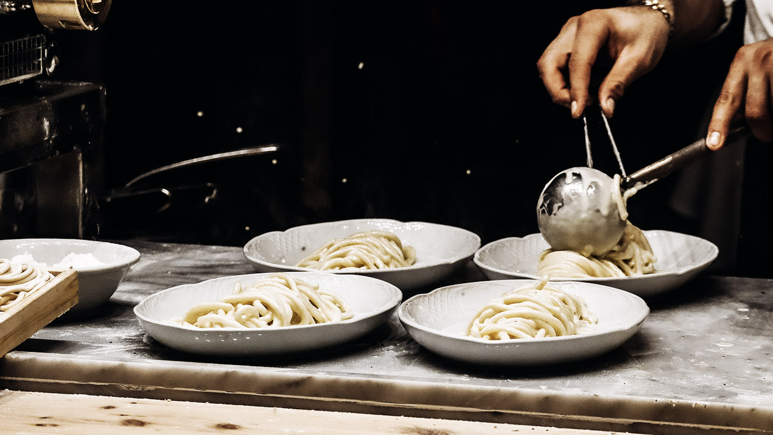 A Chef peparing pasta carbonara in a restaurante