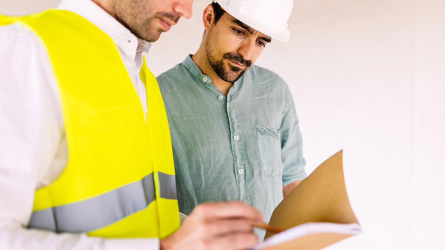 Two people looking at construction information on a notebook