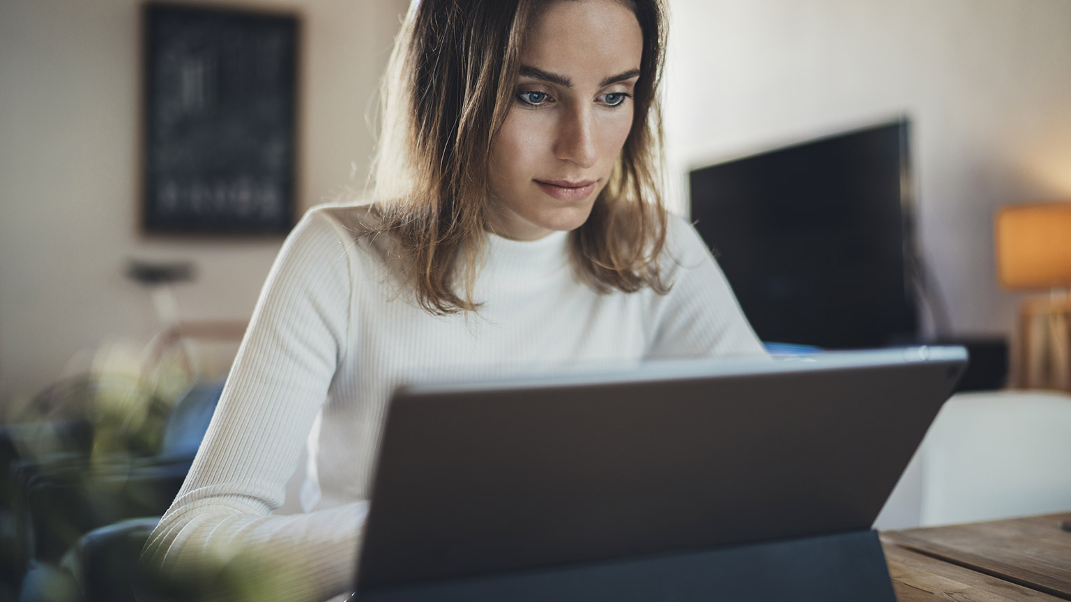 Closeup image of hipster student girl using modern digital tablet at home