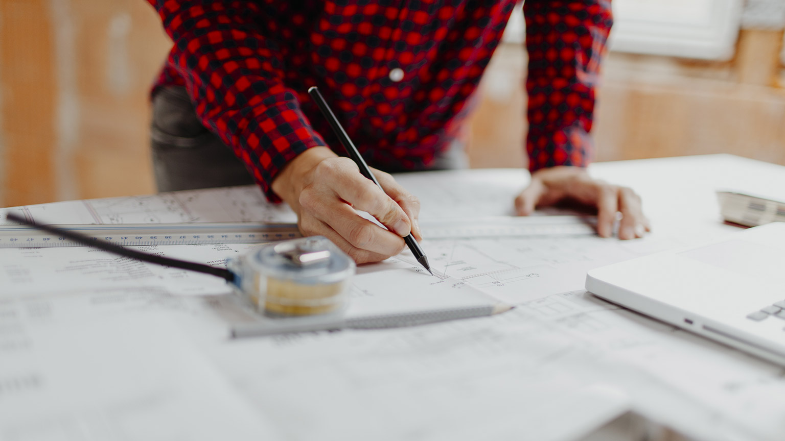 A person drawing plans on a table