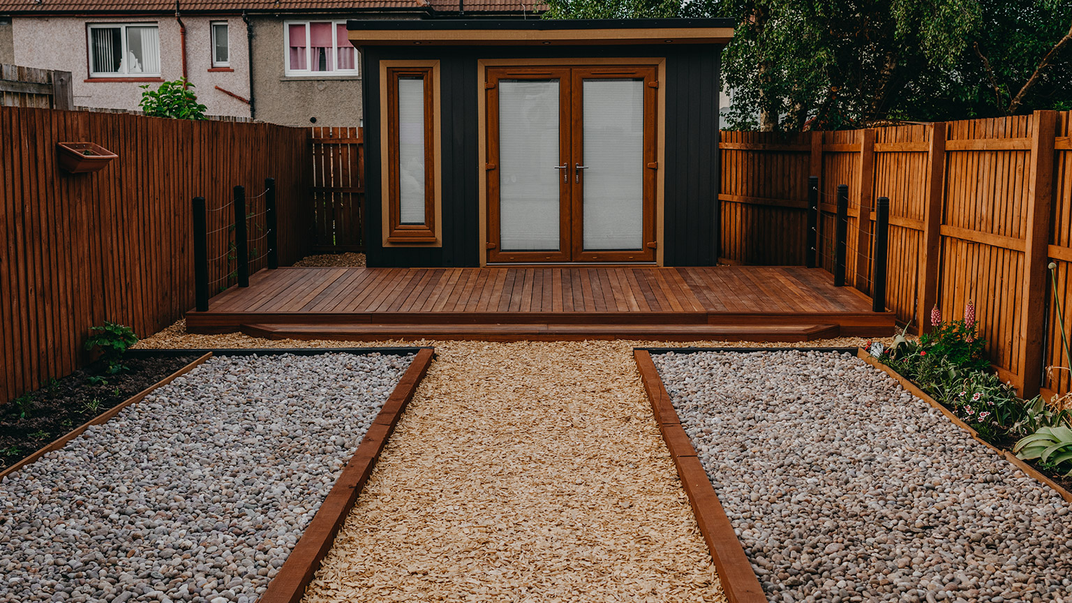 A woodchip path to an outdoor room in a backyard