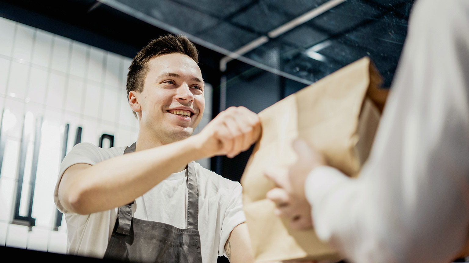 a man giving a paper bag to a customer