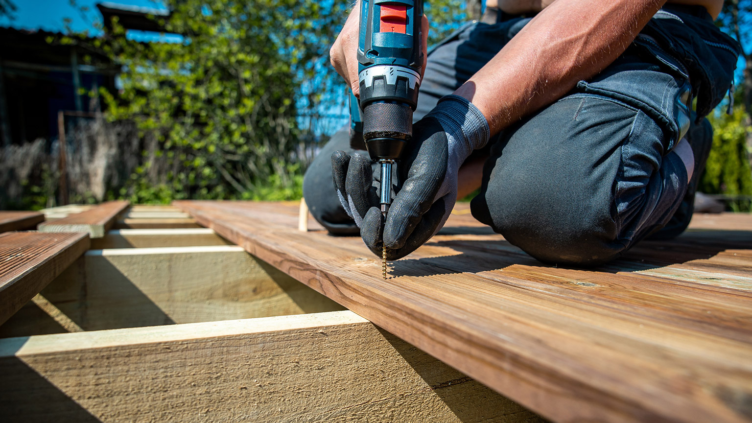 A person building an outdoor deck