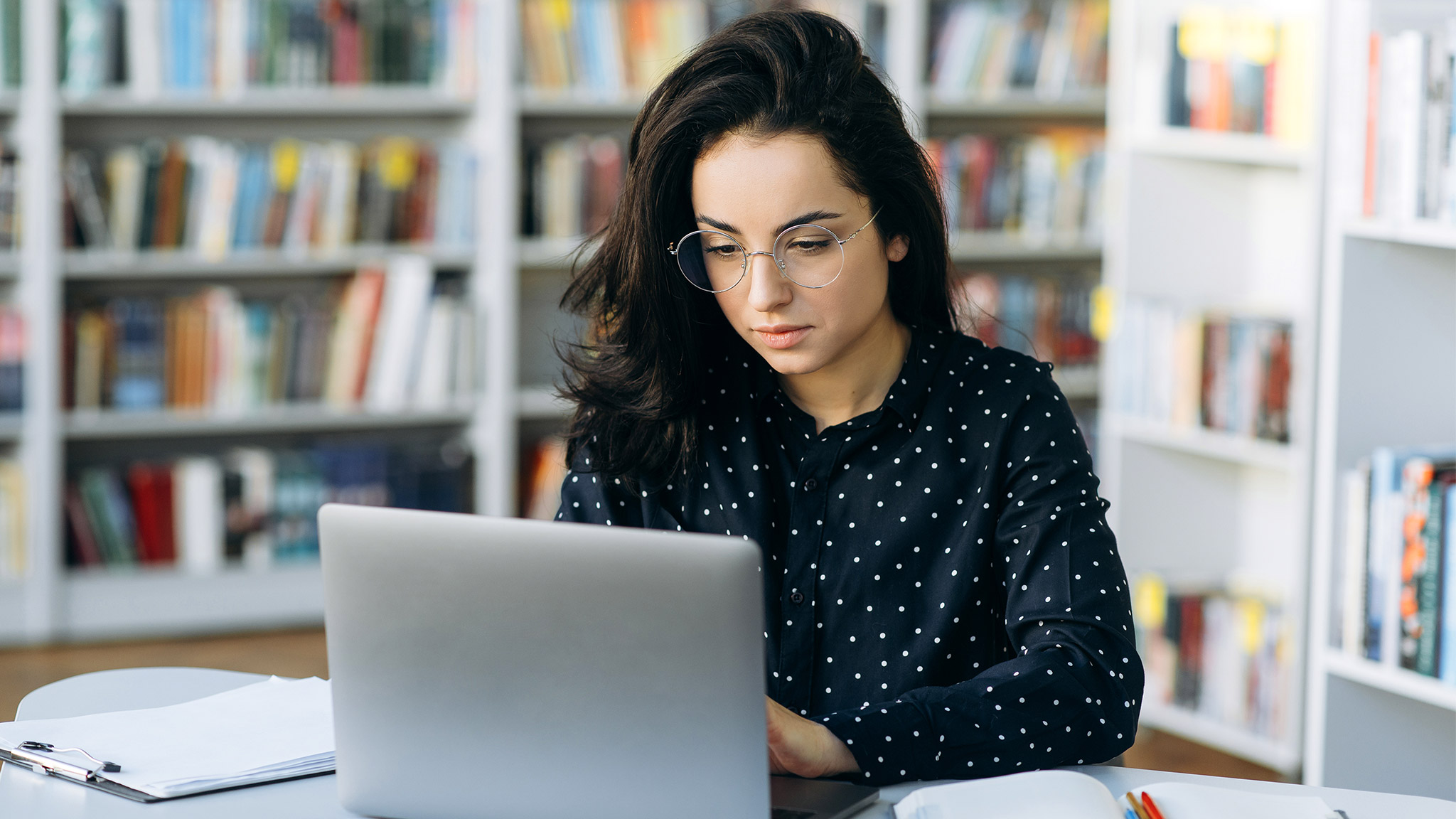 Focused caucasian young woman sit at the workplace 