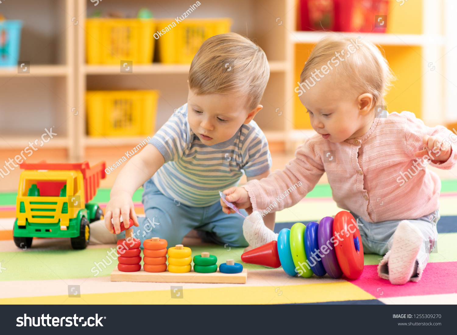 Preschool girl and boy playing on floor with educational toys 