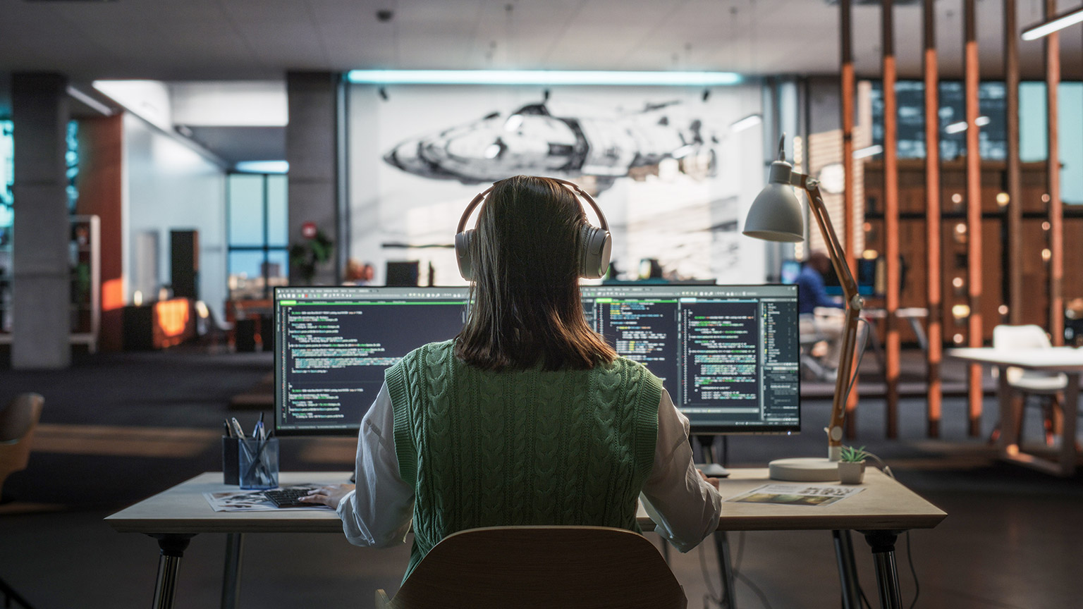 Creative Office: Professional Female Programmer Uses Headphones