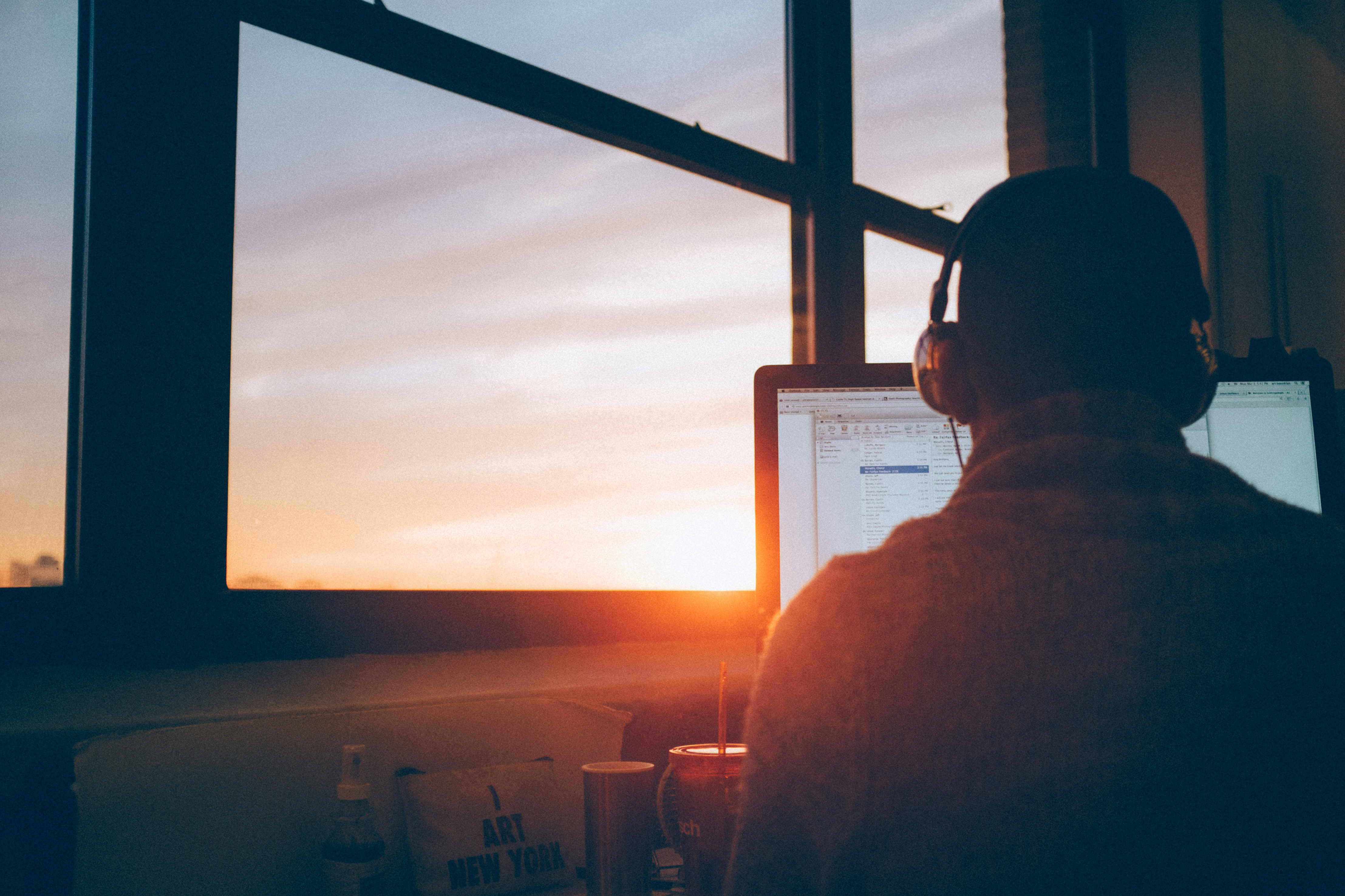 a man wearing headphones on a imac scrolling through his email