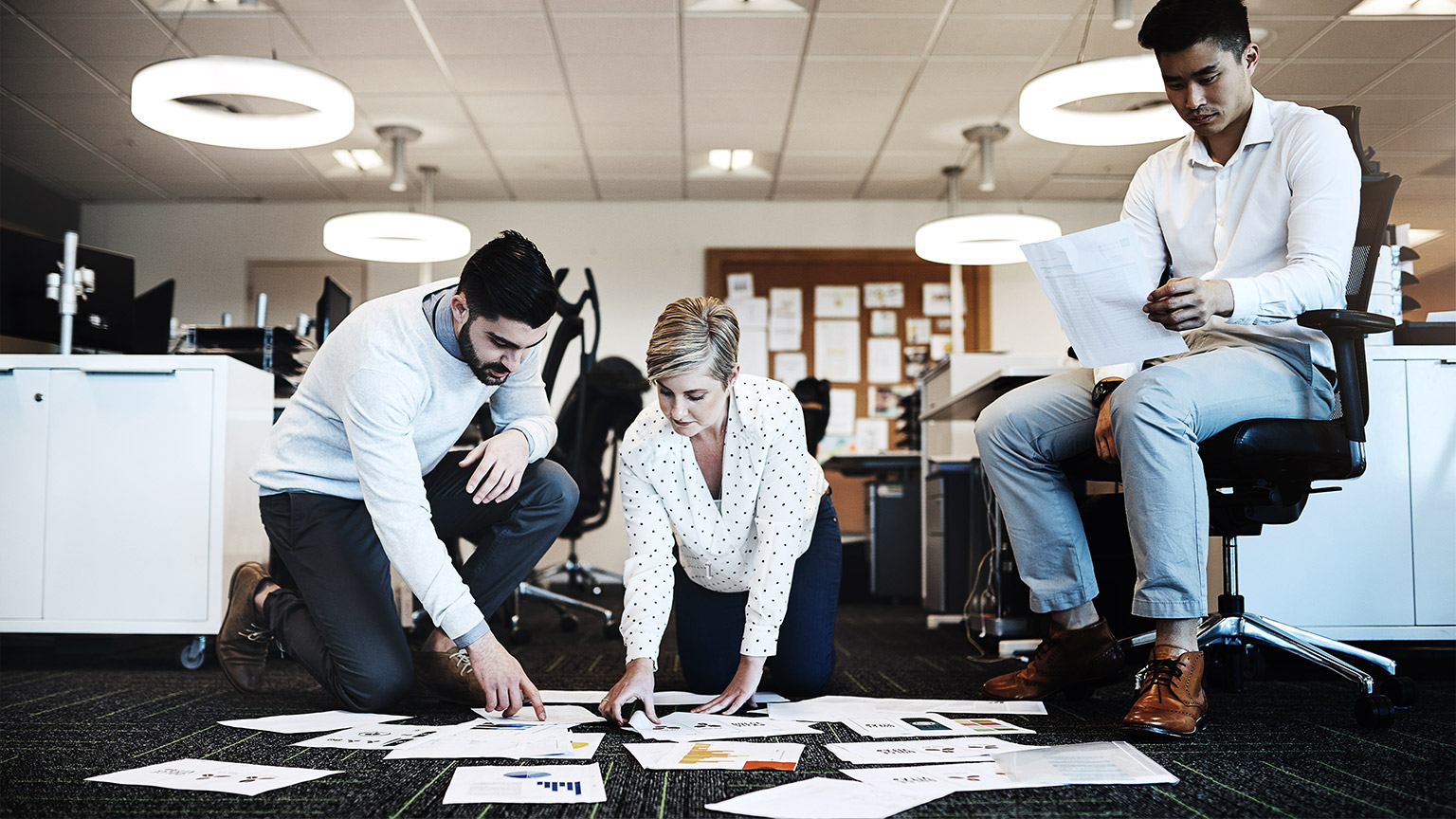 Business people, teamwork and documents on floor in office for budget review, annual report and strategy.