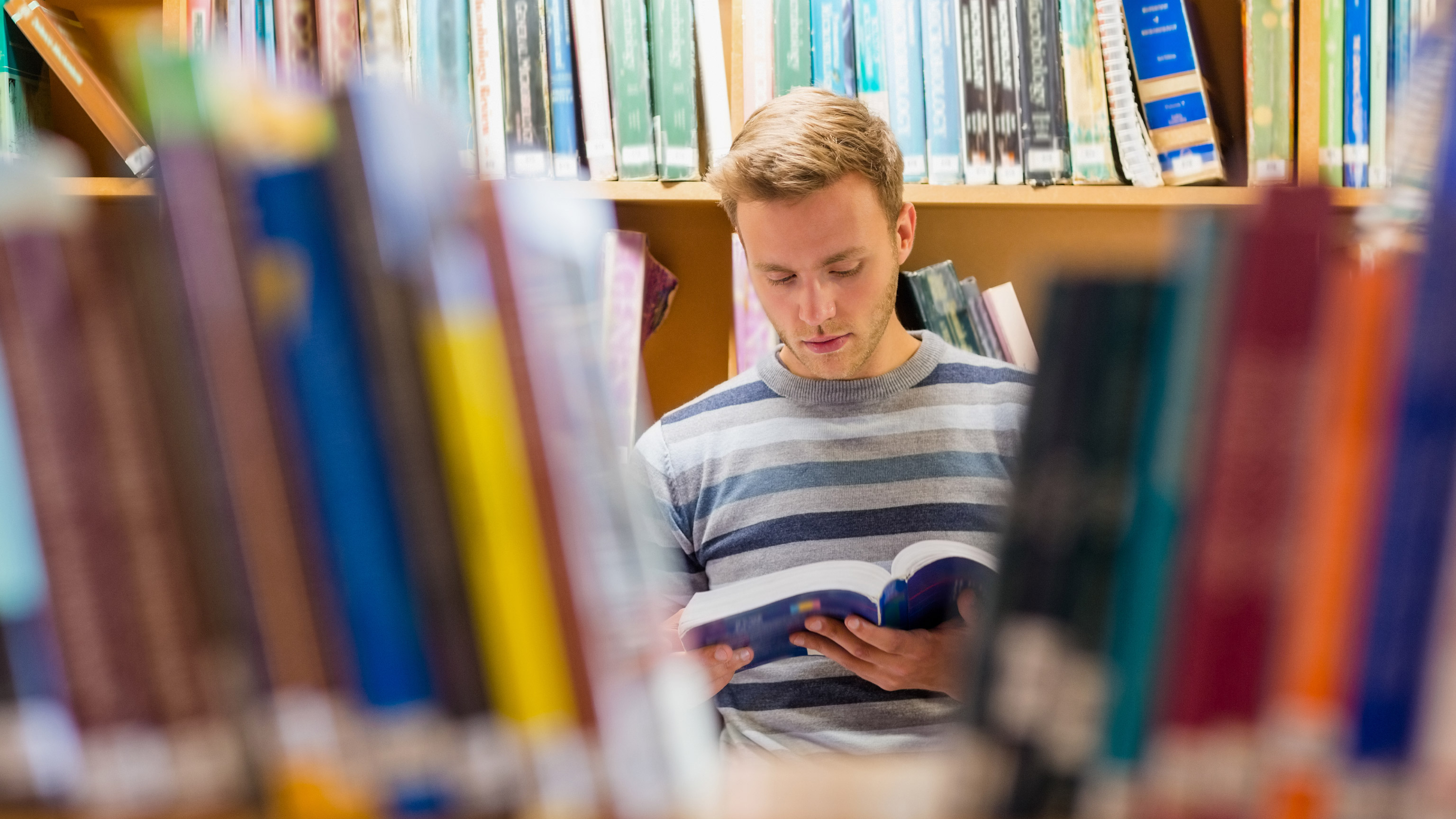 A person reading a book in a library