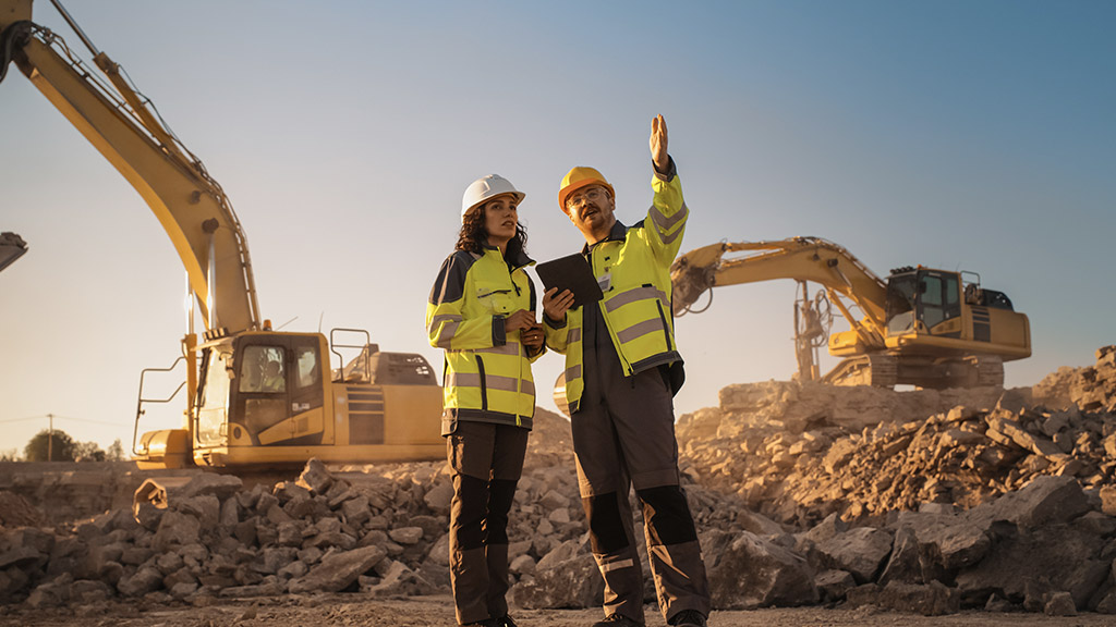 Hispanic Female Inspector Talking to Caucasian Male Land Development Manager