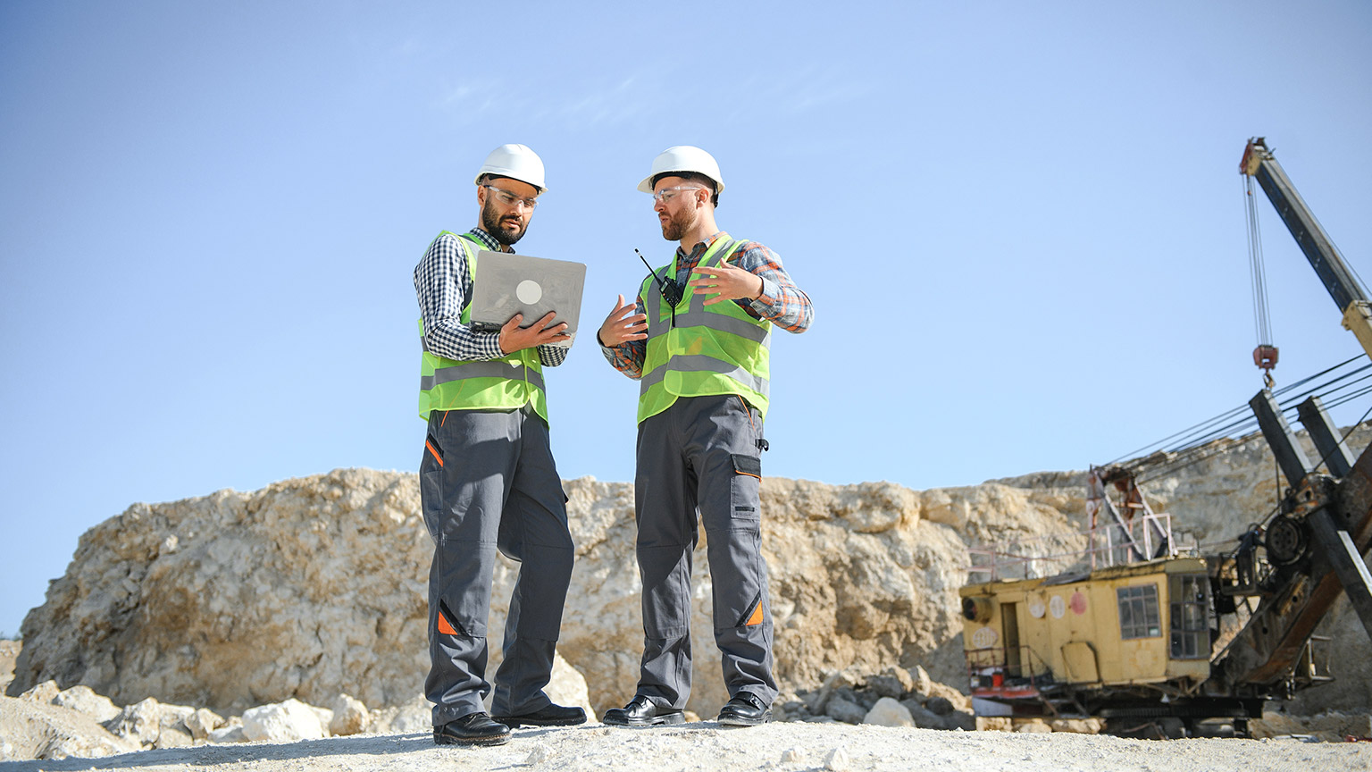 Two workers and quarry in background