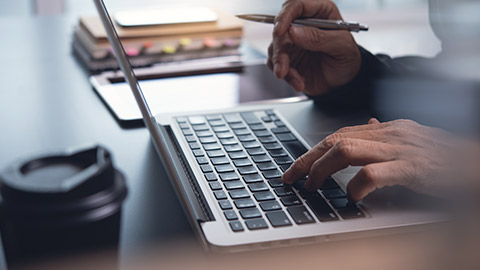 man typing on laptop computer