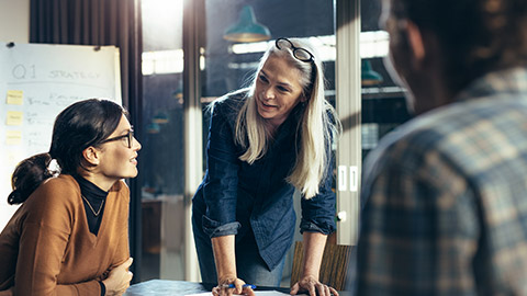 a leader explaining business matters to her team in a boardroom