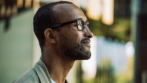 outdoor potrait of smiling man wearing eyeglasses on the street