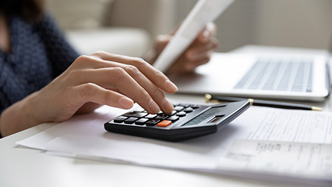 woman calculating domestic expenses involved in financial paperwork indoors