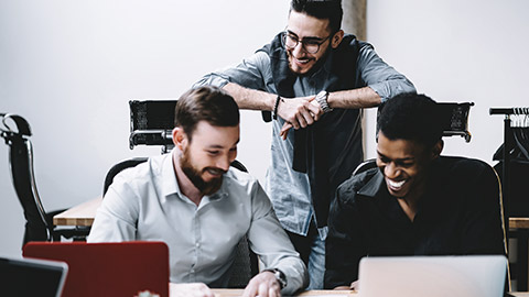 Three men happily working on a project