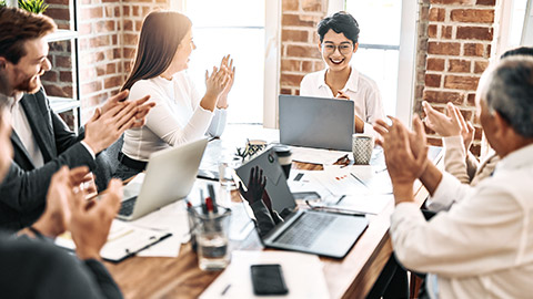 Team members applauding a colleague