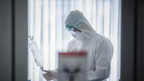 doctor in the full protective suits and surgical masks are examining the infected patient in the hospital control area