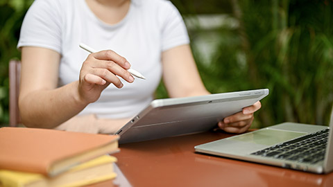 female in casual clothes using her digital tablet