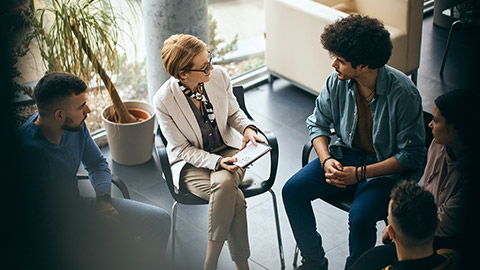 mental health professional talking to participants of group therapy at community center