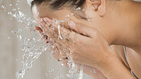 Young woman washing face