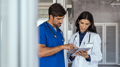 Doctor and nurse discussing over a medical report in hospital