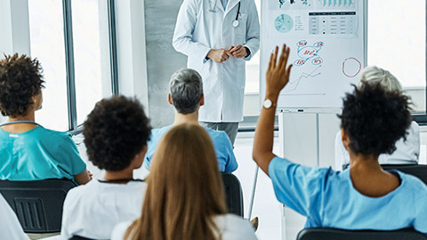 young doctor teaching on a seminar in a board room or during an educational class