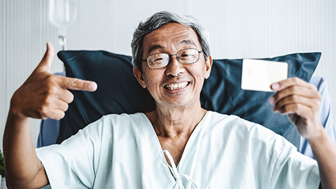 Happy patient holding health card