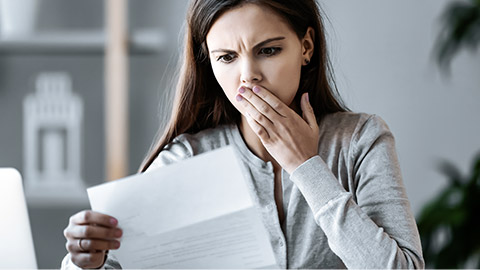 woman in shocked expression, reading a letter