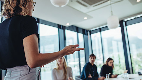 woman making a presentation to her colleagues in office