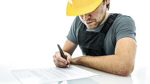 Construction worker signing a contract