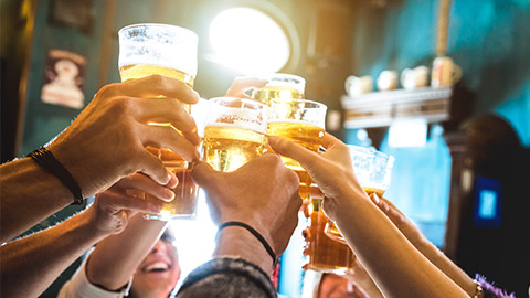 Group of happy friends drinking and toasting beer at brewery bar restaurant