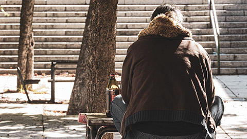 An alcoholic sitting in a park