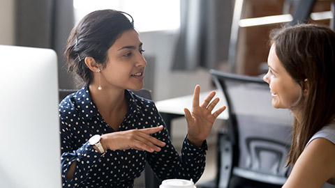 Friendly female colleagues having good relationships, pleasant conversation at workplace