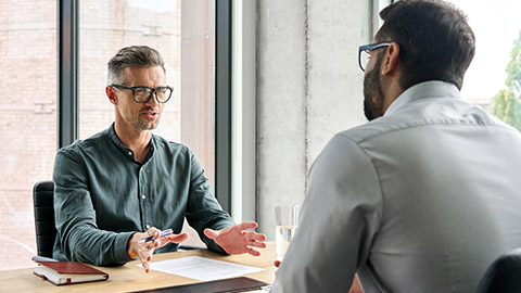 Two diverse business executive partners negotiating at board meeting