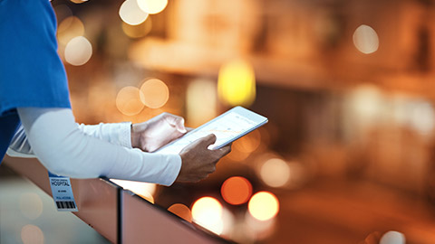 A healthcare professional reading information on a tablet device