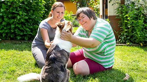 A carer with a disabled client outdoors