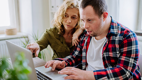 A carer assisting a disabled client use a computer