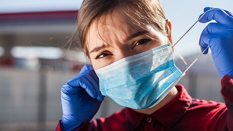 A healthcare worker putting on a mask