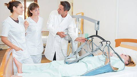 A group of workers about to lift a patient