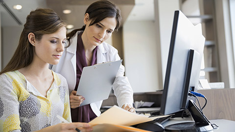 two young ladies reviewing medical records