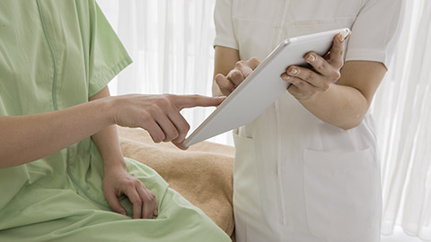 a nurse talking to a patient about her information using tablet