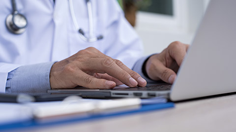 octor typing on laptop computer keyboard on office desk