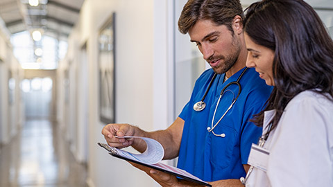 Team of doctors working together on patients file at hospital