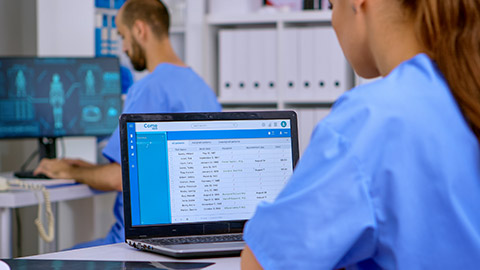 doctor assistant checking medical records on laptop