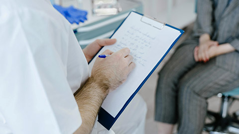 A Person Taking Notes While Talking to the Patient