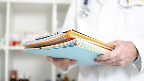 Doctor holding files in his office