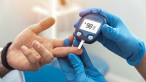 Doctor checking blood sugar level with glucometer